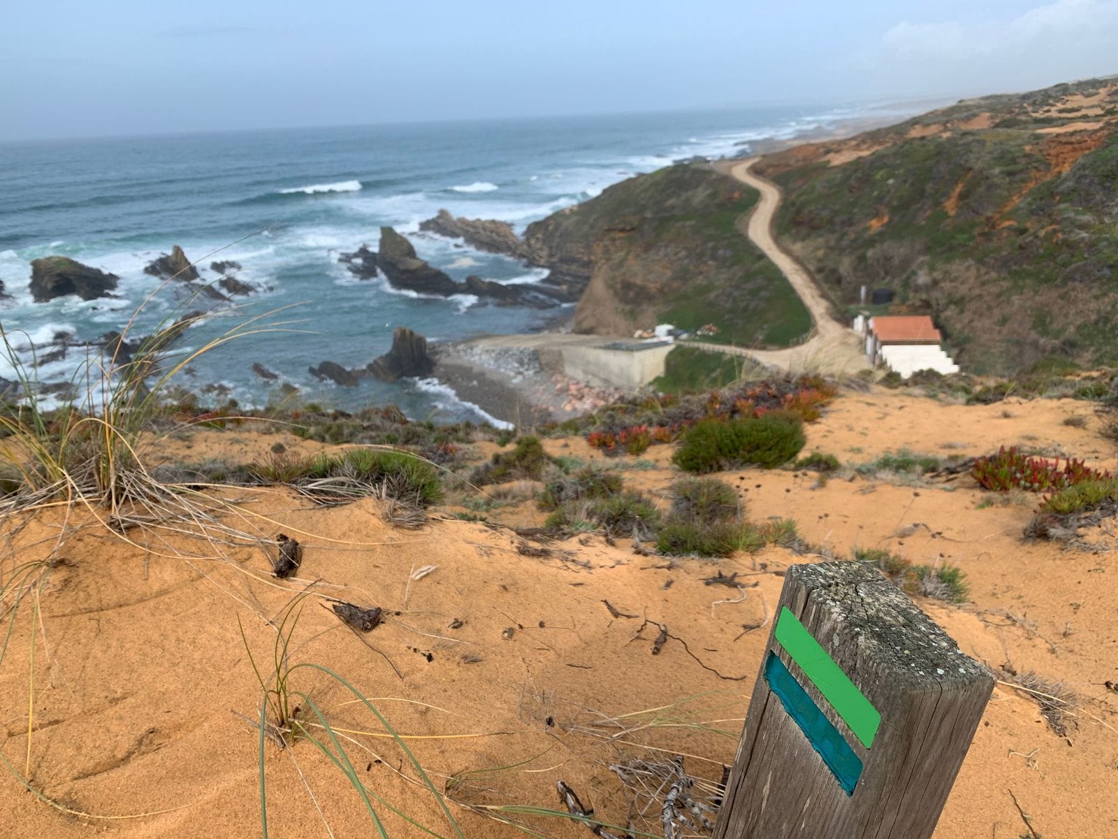 Fishermen's Trail waymarker above a small fishing harbour